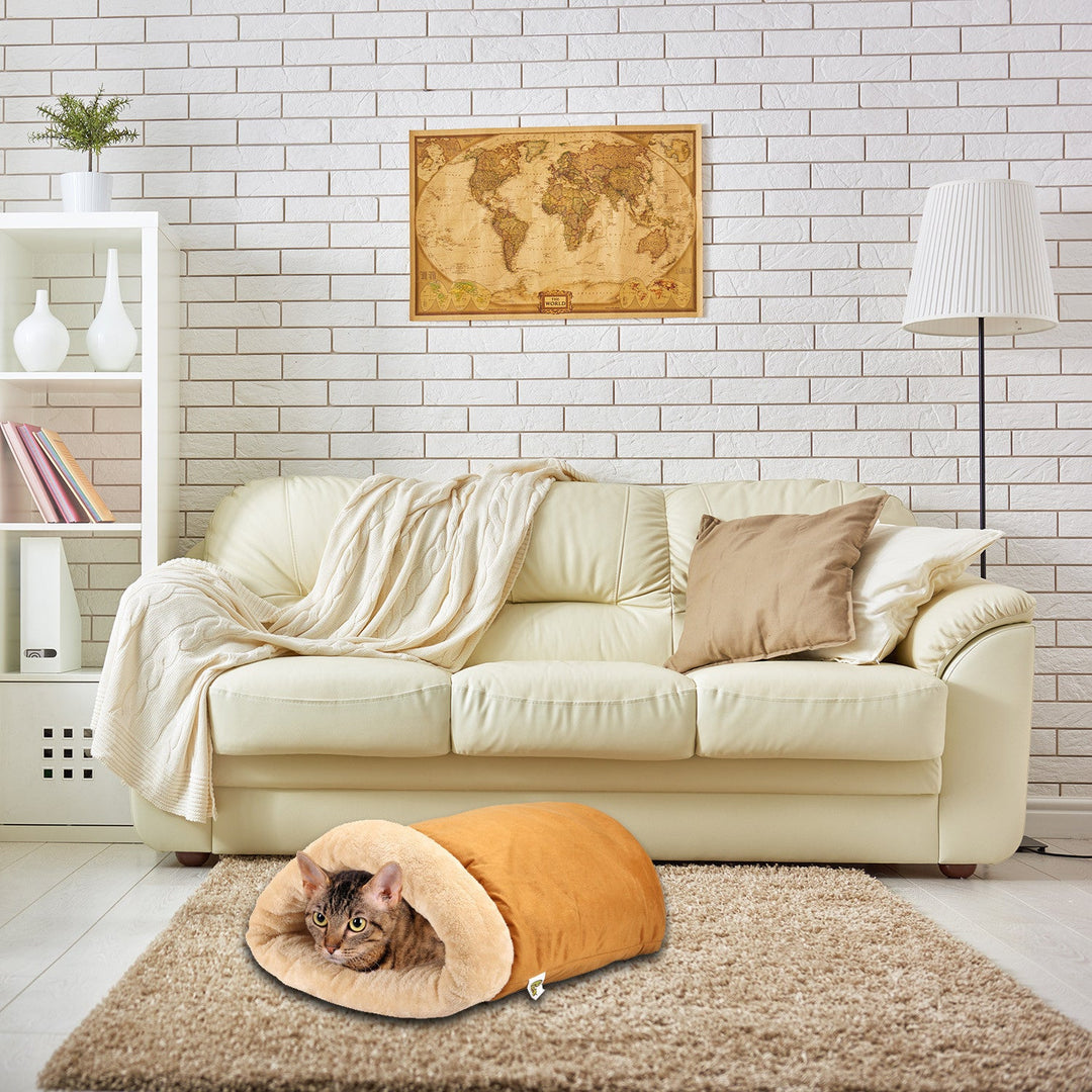 Cat cave in a living room setting on top of a rug. Cat nestled inside the cozy cave.