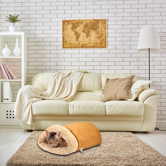 Cat cave in a living room setting on top of a rug. Cat nestled inside the cozy cave.